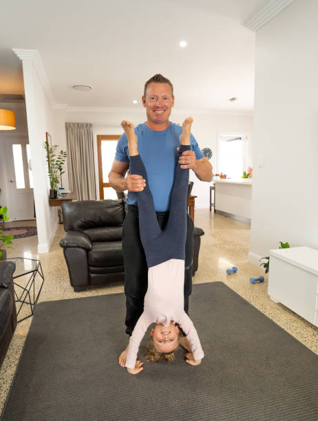 COVID-19 shutdown. Happy father and daughter exercising together during quarantine doing indoors physical activity. Stay home, Exercise, Health Self-care for Coronavirus isolationand social distancing. apagado covid-19. padre e hija felices haciendo ejercicio juntos durante la cuarentena haciendo actividad física en interiores. quédate en casa, ejercicio, autocuidado de salud para el aislamiento del coronavirus y distanciamiento social.