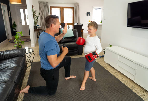 istock COVID-19 lockdon. Father and son having fun boxing together and staying physically active at home during coronavirus quarantine. Stay home, Exercise, Health Self-care during social distancing. 1223161006