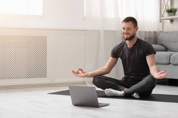 istock Millennial guy meditating with trainer online via laptop 1223161733