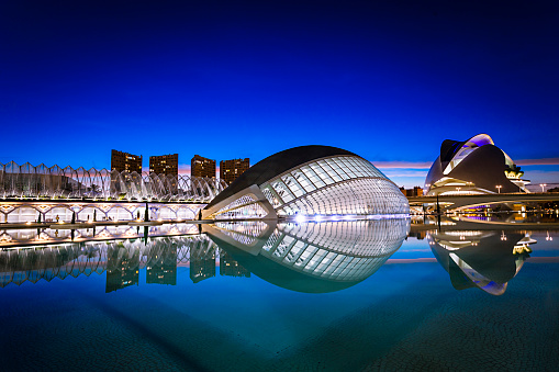 Valencia, Spain. March 11, 2018 City of Arts and Sciences, in Valencia. Night view of Hemispheric Theater. These futuristic buildings, designed by valencian architects Santiago Calatrava and Manuel Candela are icons of Valencia city. The City of Arts and Sciences is located at the end of the old riverbed of the river Turia and became a garden in the 80'. Photo taken at twilight.