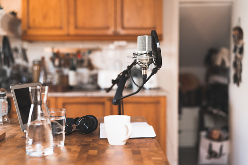 Podcast recording and broadcasting equipment in someones home. Everything is on a table in the kitchen.