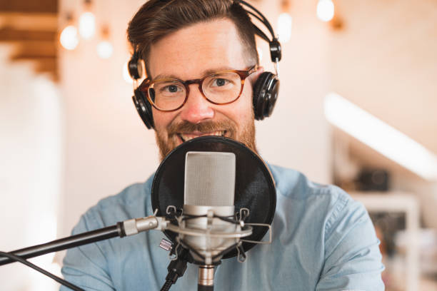 istock Cheerful man recording a podcast from home 1223166302