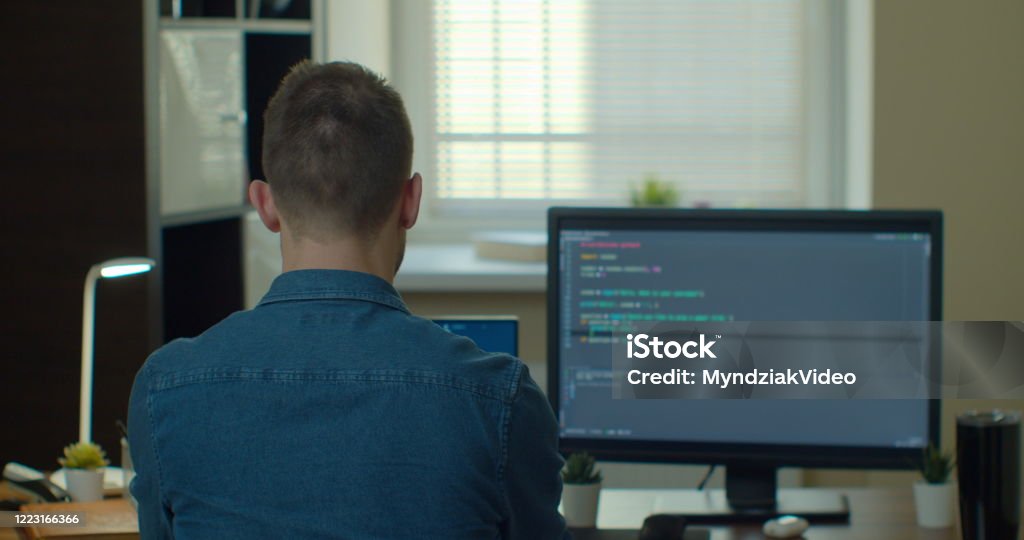 Young Man Freelancer Coding Html And Programming On Two Screen Monitors ...