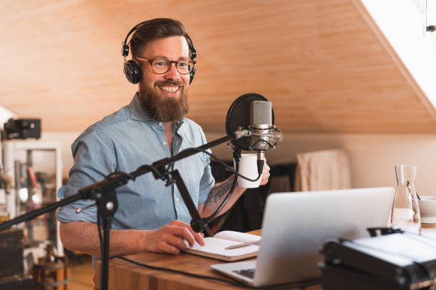 istock Cheerful man recording a podcast from home 1223166370