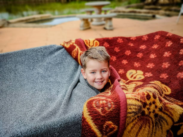 istock Boy emerges from tente cave built with blankets. 1223167349