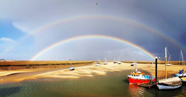 Double Rainbow at Wells-next-the-Sea, Norfolk, UK A rare glimpse of a double rainbow over the harbour at Wells-next-the-Sea in Norfolk, UK. low tide stock pictures, royalty-free photos & images