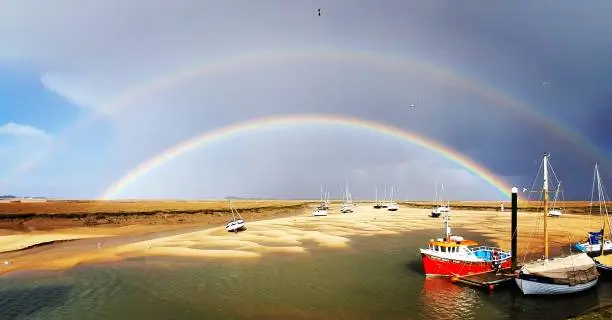 A rare glimpse of a double rainbow over the harbour at Wells-next-the-Sea in Norfolk, UK.