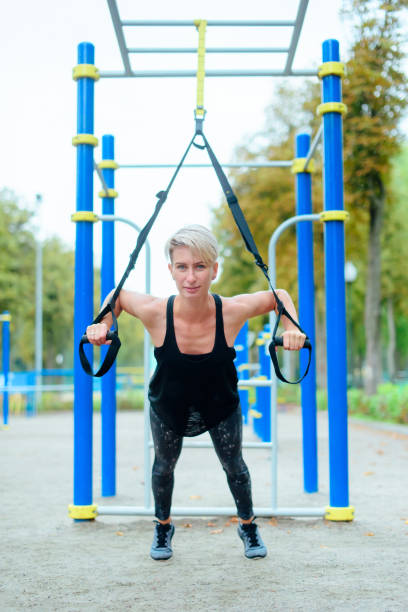 istock young girl, woman doing exercises outdoors using slings, TRX loop 1223169065