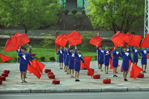 Pyongyang, North Korea - April 30, 2019: Girls with red flags  perform morning show on the streets of the city to create a good mood among citizens