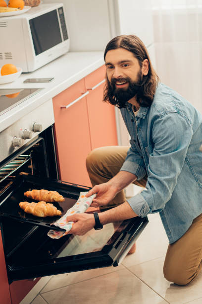 istock Positive man feeling happy while baking croissants 1223169438