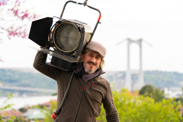 el trabajador del cine con grandes luces de fresnel. el diseñador de iluminación - fresnel fotografías e imágenes de stock