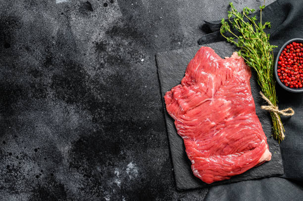 istock Raw outside skirt steak, marbled meat. Black background. Top view. Copy space 1223171319