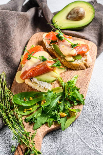istock Toasts with avocado and smoked salmon.  White background. Top view 1223173309