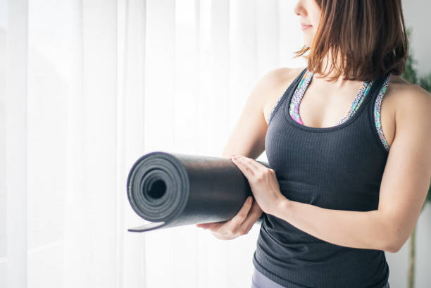istock Woman holding a yoga mat. 1223175046