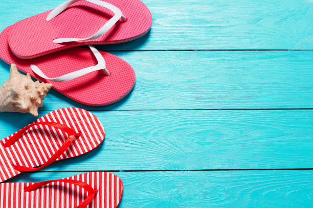 istock Summer flip flops with shell and copy space on blue wooden background. Top view. Summertime. Fun weekend holidays 1223177298