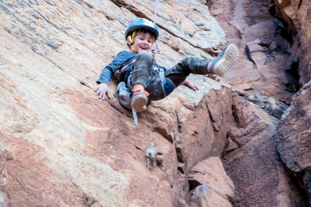 istock A young boy is lowered down the cliff face. 1223180020
