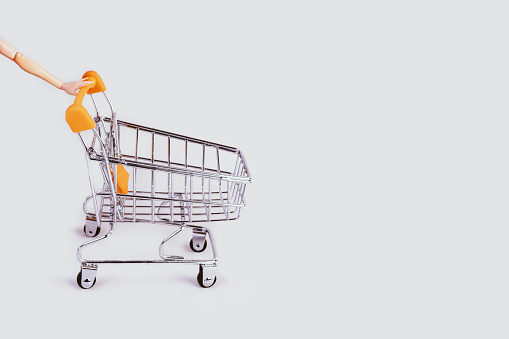 Banner with shopping cart and hand. Grocery shopping and sale concept. Black friday, online shopping and store concept. Sale discount. Background with copyspace. Creative design. Stock photography.