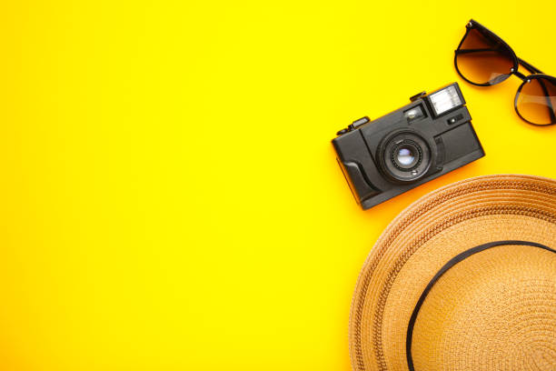 istock Beach hat with camera and sunglasses on yellow background 1223182516