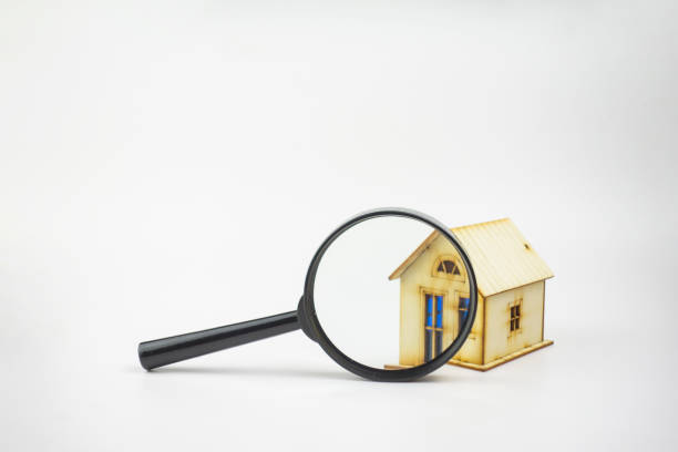 istock Small house and magnifying glass on white background 1223184105