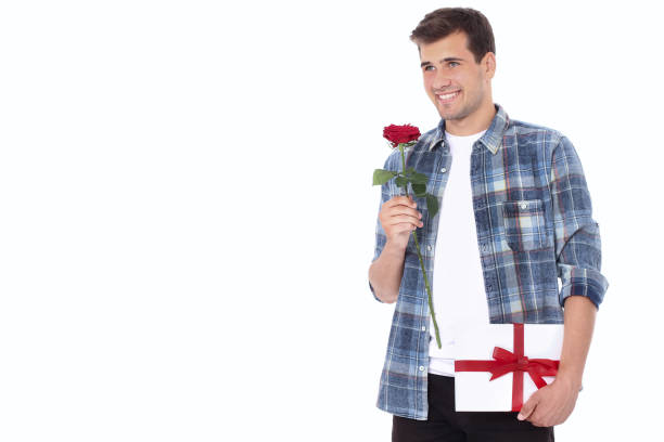 Romantic young man with red rose and gift box isolated on white. Mock up and copy space.