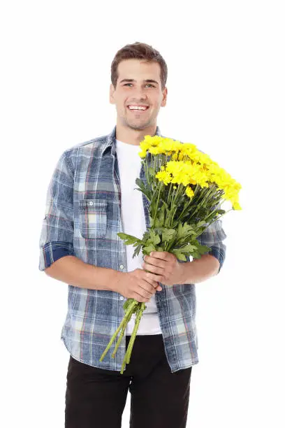 Photo of Mothers day. Smiling handsome man with yellow bouquet of flowers isolated on white. Copy space and mock up