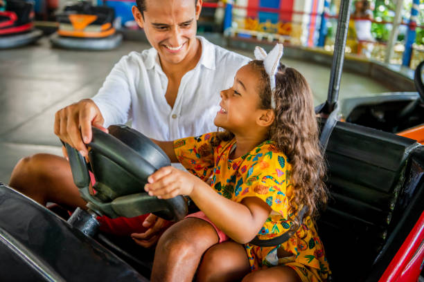 padre e hija conducen coche parachoques en el parque de amusment - amusment park fotografías e imágenes de stock