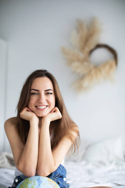 istock Young beautiful girl at home with a globe. 1223187492