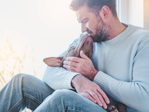 istock Handsome man and a charming puppy. Close-up 1223187558