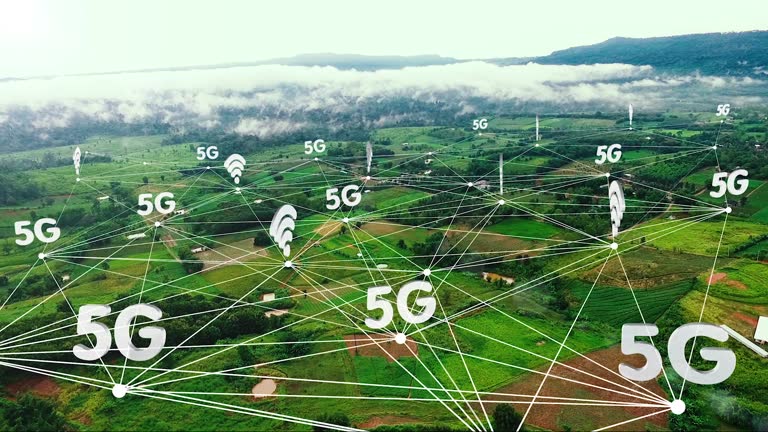 Aerial view, 5G technology icon with network on green farm fields near the mountains.