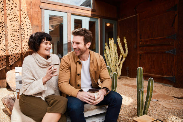 istock Smiling young couple sitting outside their home talking over coffee 1223193769