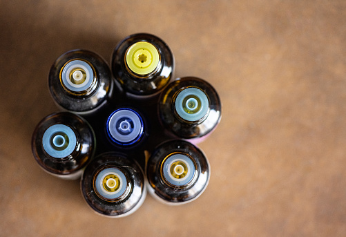 This is a photograph of the top of an essential oil bottles arranged in a flower of life geometry pattern viewed from above during lockdown at home in Miami, Florida.