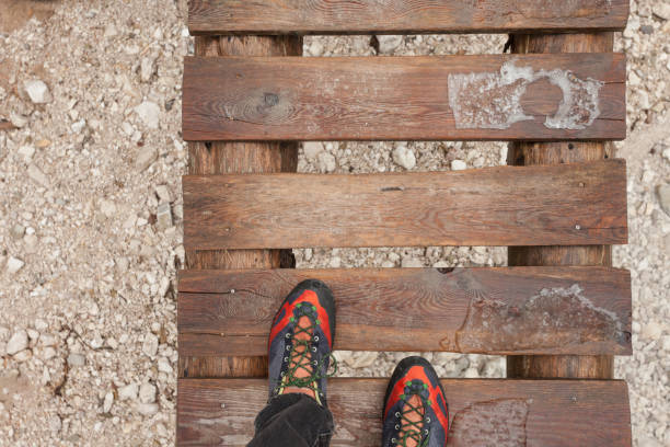 a trekker walking long a small  wooden bridge