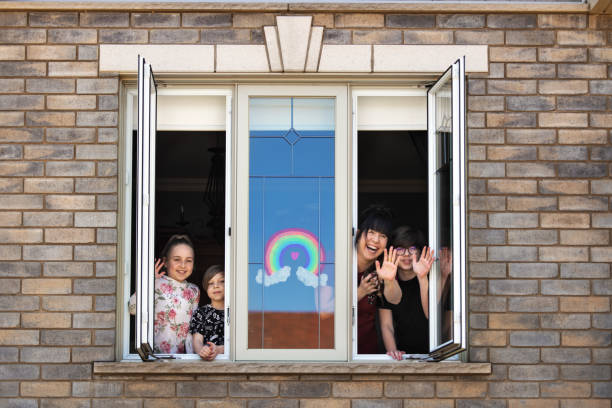 Quarantined family, posing in window , Quebec, Canada
