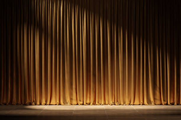 Theater stage with golden curtains and spotlights.