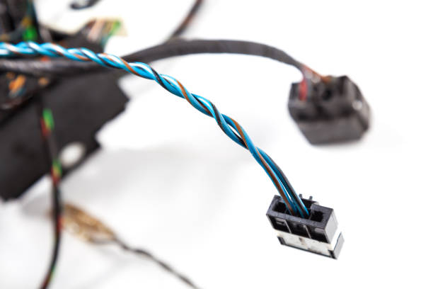 istock Two twisted blue electrical wires with a black connector closeup on a white background and other cables. Installation and connection of Internet daily routine of the engineer and system administrator. 1223202120