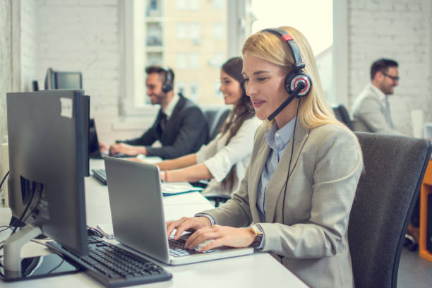istock Beautiful young woman with headset using laptop while talking with a client. Online customer care support service. 1223203745