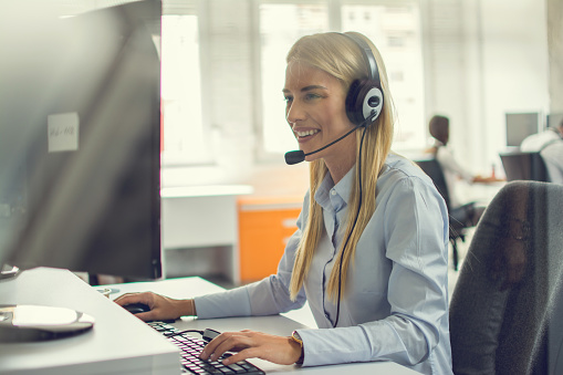 Professional helpline call center agent operator woman wearing headset working in customer care support centre.