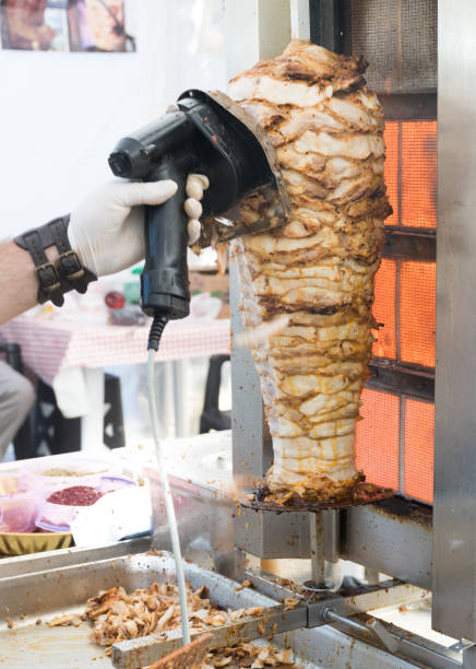 istock Turkish shawarma roasting on vertical skewer Grilled skewered chicken on spit 1223205239
