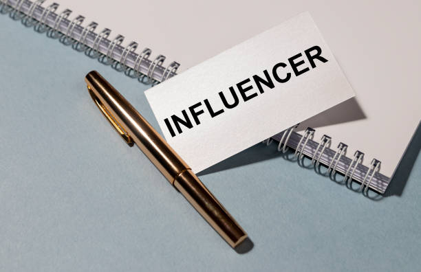 istock influencer - word abstract on white paper on notebook and pen on grey blue table 1223206991