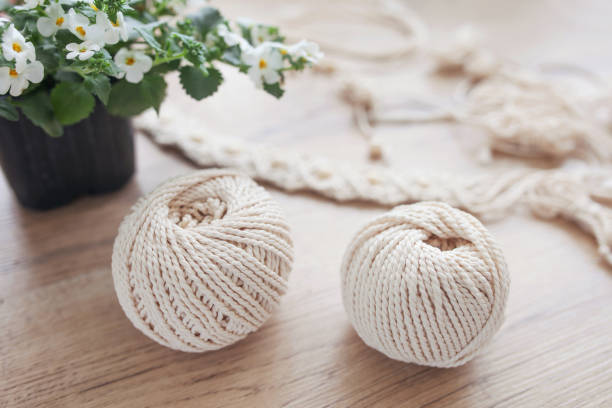 istock Handmade macrame braiding and cotton threads on rustic wooden stick. Boho image good for macrame and handicrafts banners and advertisement 1223207184