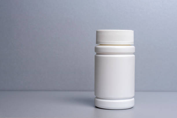 istock 1 white jar for medicines and vitamins and dietary supplements without a name are on a gray shelf. copy space to the left. layout for a pharmacy, a store 1223210326