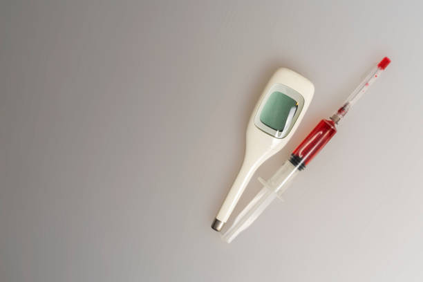 istock syringe filled with red liquid and electronic thermometer on a light background 1223210560