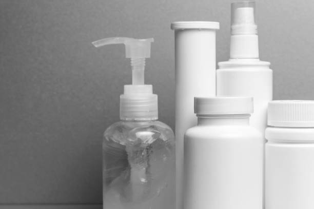istock 5 containers without inscriptions for medicines, vitamins, sprays, antiseptic gel stand on a gray shelf. layout for the design of the pharmacy and the store. monochrome 1223210571