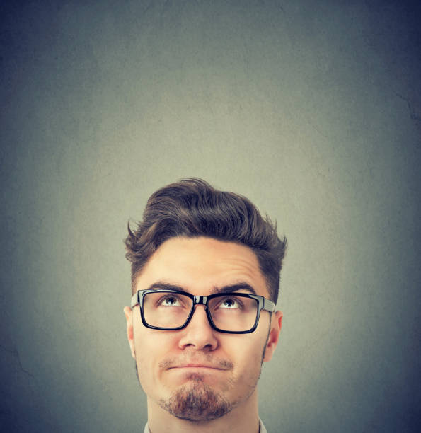 istock Serious man wearing black glasses looking up thinking 1223211608