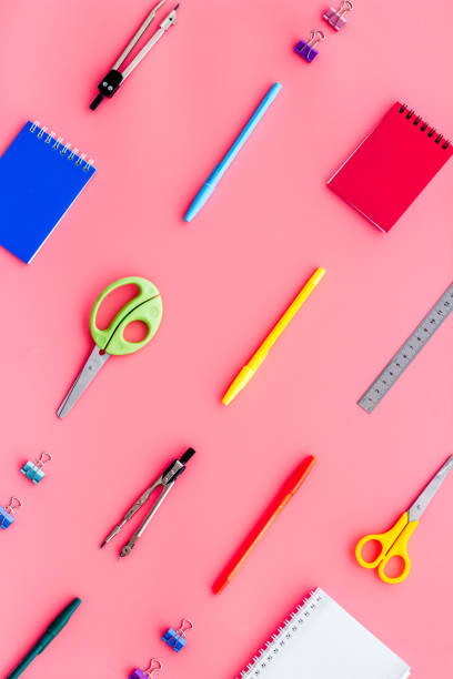 istock School supplies pattern - notebook, pen, ruler, sciccors - on pink table top-down 1223213296