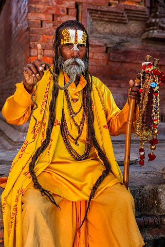 In Hinduism, sadhu, or shadhu is a common term for a mystic, an ascetic, practitioner of yoga (yogi) and/or wandering monks. The sadhu is solely dedicated to achieving the fourth and final Hindu goal of life, moksha (liberation), through meditation and contemplation of Brahman. Sadhus often wear ochre-colored clothing, symbolizing renunciation.