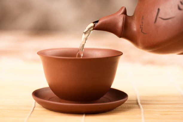 istock Pouring green Chinese tea into a clay bowl. 1223216588