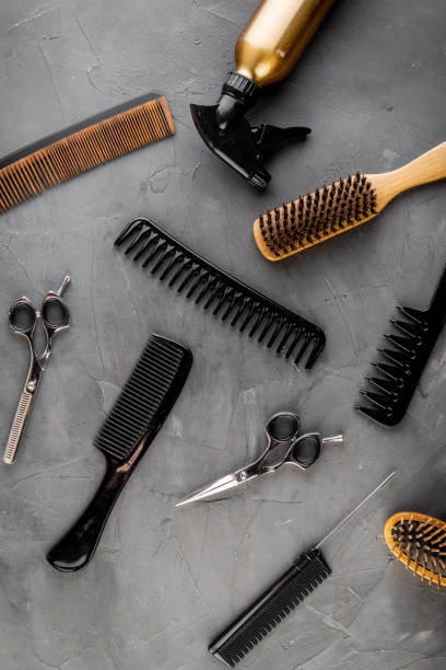 istock Hairdressing instruments. Combs, scissors and spray on grey desk from above 1223216718