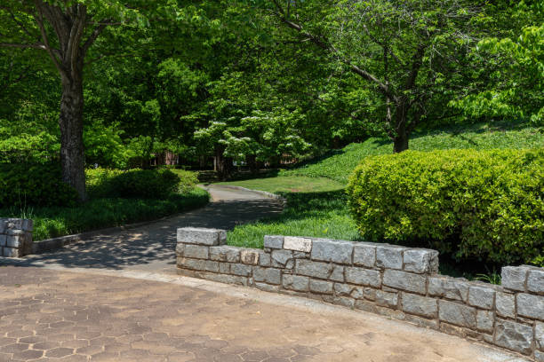 istock Low granite block wall, path through an urban park in spring, green landscape with creative copy space 1223218433