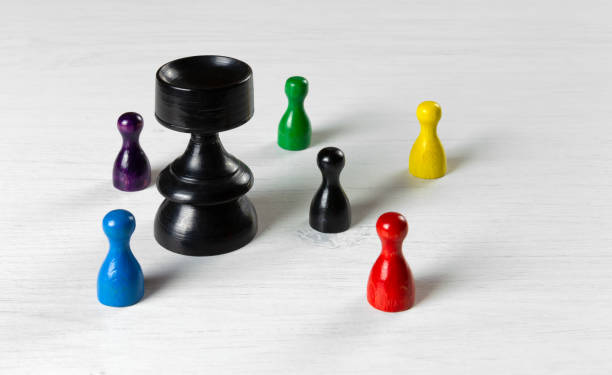 bauern unterschiedlicher größe auf einem weißen tisch - armed forces black yellow chess pawn stock-fotos und bilder